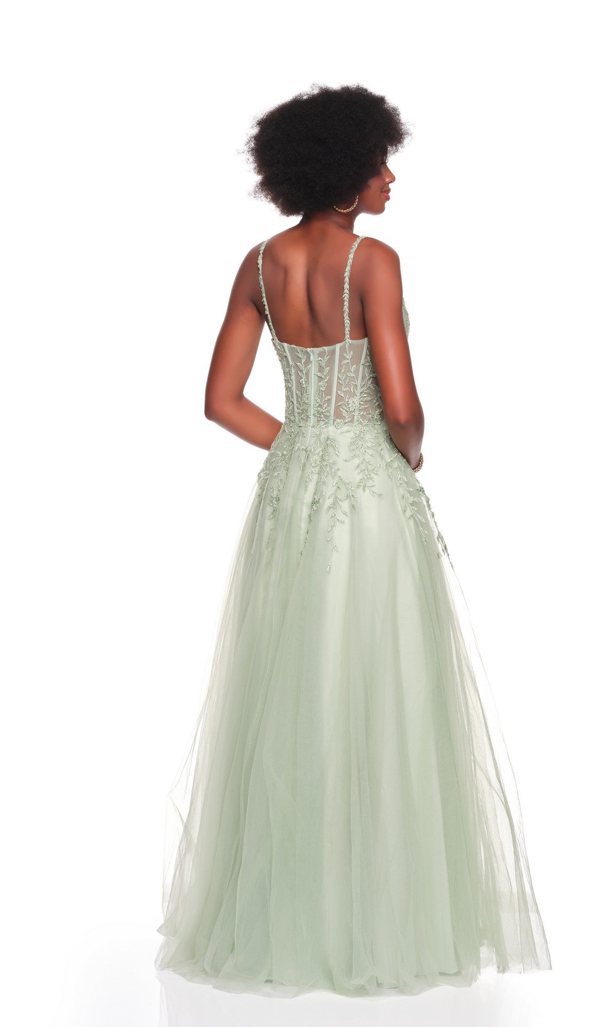 A woman faces away, wearing the Dave and Johnny 12907 long prom dress in light green with an embroidered bodice and sheer A-line tulle skirt, set against a plain white background.